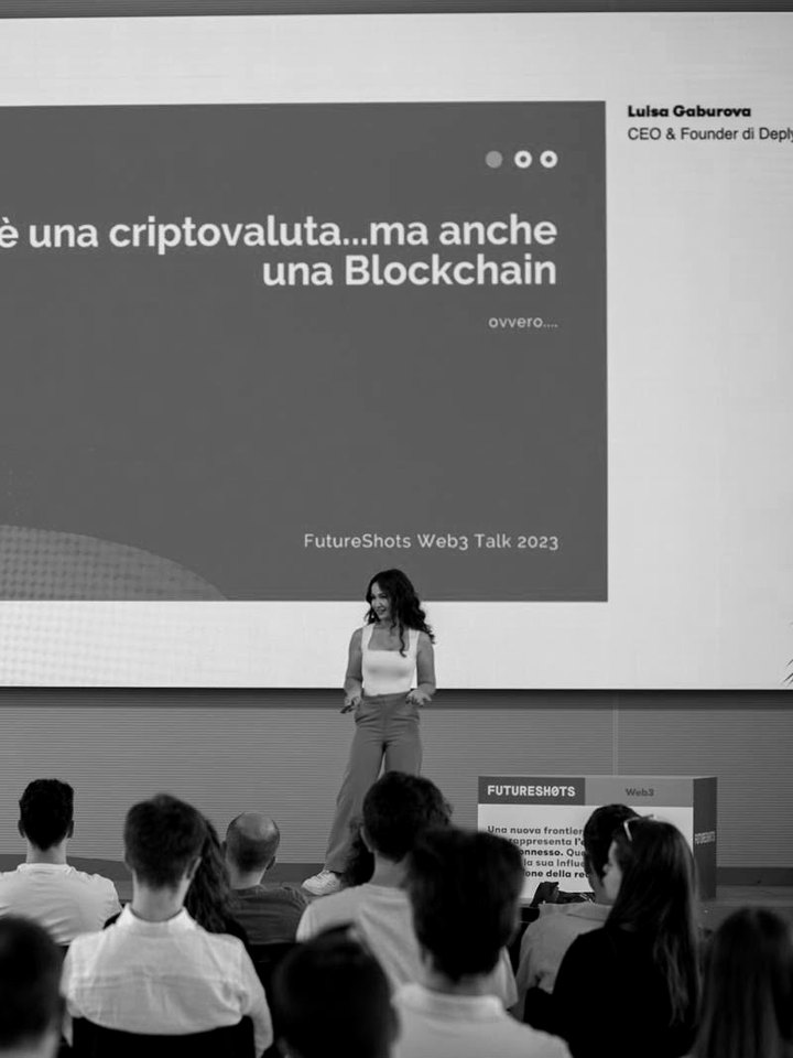 Luisa speaking on stage to a full audience at FutureShots